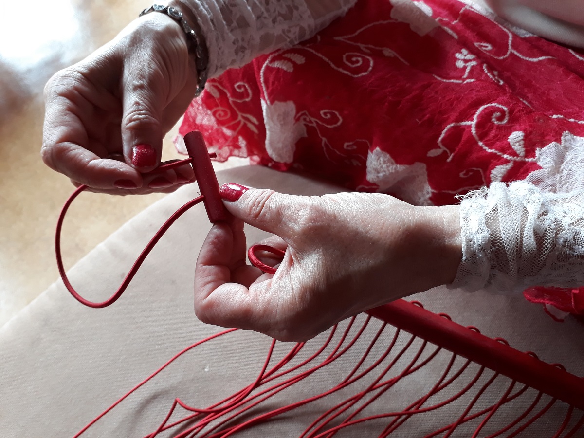 Photo of threading a red wooden toggle.