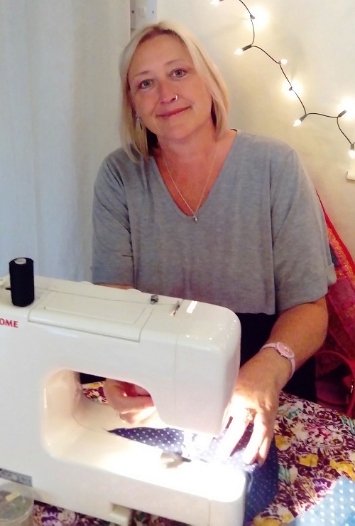 Photo of installation artist Claire Johnson sewing.