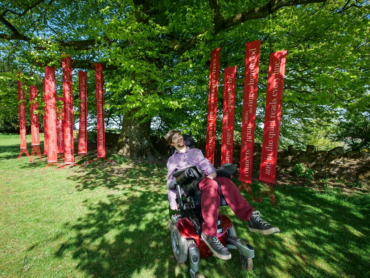 Photo of Marchant at the Kymin, in front of the 'Beech Book' poem installation